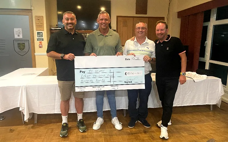 Donators holding large charity donation cheque 